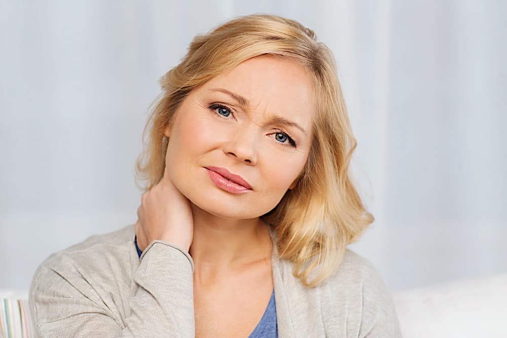 Unhappy Woman Suffering From Neck Pain At Home